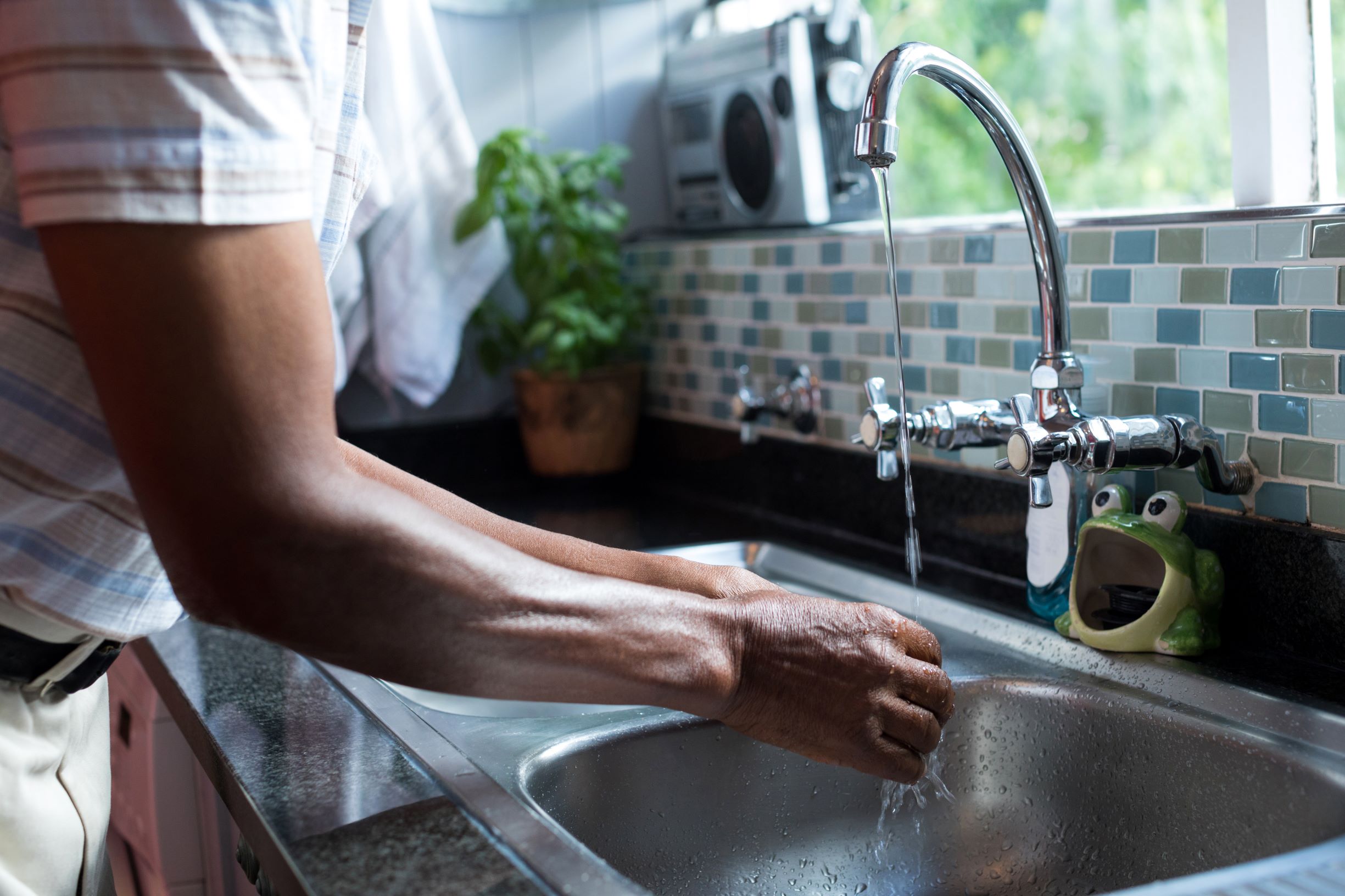 adult washing hands at sink in kitchen 2026 01 09 08 35 36 utc1