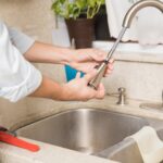 repairman fixing the kitchen faucet at home 2026 01 09 11 44 38 utc Large